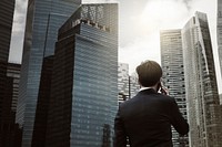 Young businessman on phone city background