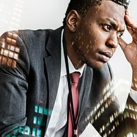 Stressed black businessman with city background