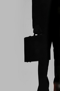 Businessman with a briefcase in the dark