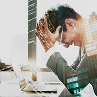 Stressed businessman at work on city background