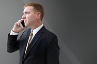 Businessman talking on phone on gray background