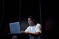 Japanese man working on a laptop at a modern office space