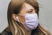 Woman in a face mask listening to music  during coronavirus pandemic