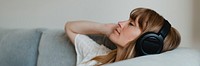 Woman listening to music  during coronavirus quarantine on a couch