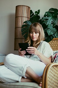 Woman reading an e-book on a digital tablet  during coronavirus quarantine