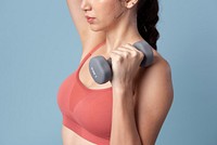 Sporty woman lifting dumbbells on blue background