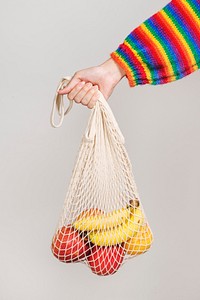 Woman using a net bag to carry fruits