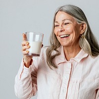 Cheerful senior woman drinking a glass of milk