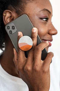 Round phone grip behind the mobile with African American woman talking on the phone