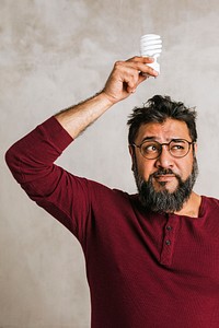 Happy Indian man holding a light bulb 