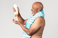 Senior African American man holding a sunscreen lotion bottle