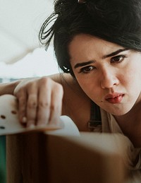 Determined female carpenter preparing wood with sandpaper