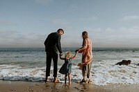 Happy family holding hands at the beach on vacation