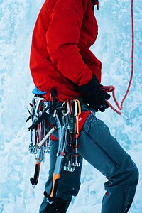A person with ice climbing gear strapped to a harness on an ice wall. Original public domain image from <a href="https://commons.wikimedia.org/wiki/File:Mountain_climber_at_Bridal_Veil_Falls_(Unsplash).jpg" target="_blank" rel="noopener noreferrer nofollow">Wikimedia Commons</a>