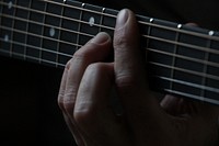 A close-up of a person's hands on the neck of a guitar. Original public domain image from <a href="https://commons.wikimedia.org/wiki/File:Fingers_on_frets_(Unsplash).jpg" target="_blank" rel="noopener noreferrer nofollow">Wikimedia Commons</a>