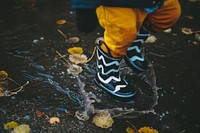 A little kid splashing in the water in wellies in Rīgas pilsēta. Original public domain image from Wikimedia Commons