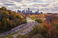 Long shot of busy daytime highway traffic with autumnal trees at Leaside Bridge. Original public domain image from Wikimedia Commons