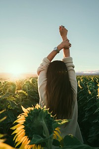 A woman facing the sunlight in sunflower field. Original public domain image from Wikimedia Commons