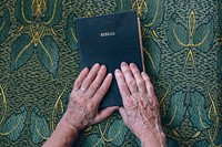 Religious senior woman pray on the bible. Original public domain image from Wikimedia Commons