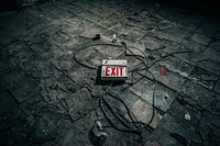 Abandoned building with exit sign on the floor. Original public domain image from Wikimedia Commons