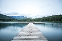 A long wooden pier on a smooth lake. Original public domain image from Wikimedia Commons