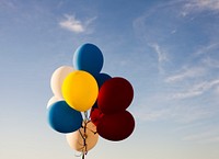 Colorful balloons on a string against a blue sky. Original public domain image from Wikimedia Commons