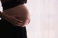 Pregnant woman in black holds her exposed stomach expectantly. Original public domain image from <a href="https://commons.wikimedia.org/wiki/File:Expecting_(Unsplash).jpg" target="_blank" rel="noopener noreferrer nofollow">Wikimedia Commons</a>