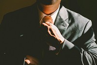 Businessman in black suit loosening his tie. Original public domain image from <a href="https://commons.wikimedia.org/wiki/File:Elegant_man_loosening_tie_(Unsplash).jpg" target="_blank">Wikimedia Commons</a>