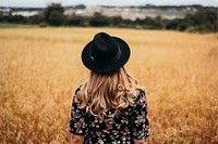 Woman standing on a golden hay field. Original public domain image from Wikimedia Commons