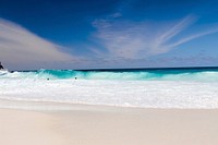 Blue ocean waves splashing on a tropical sand beach at Seychelles. Original public domain image from Wikimedia Commons