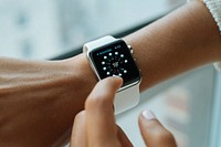 Macro of an olive-skinned person using and wearing an Apple watch with a white band showing the weather for Montreal. Original public domain image from Wikimedia Commons