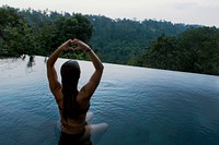A woman meditating in an infinity pool overlooking a forest. Original public domain image from <a href="https://commons.wikimedia.org/wiki/File:Pool_meditation_(Unsplash).jpg" target="_blank">Wikimedia Commons</a>