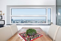 A potted plant on a table in a room with a wide window looking out on the city. Original public domain image from <a href="https://commons.wikimedia.org/wiki/File:Dining_with_a_view_(Unsplash).jpg" target="_blank" rel="noopener noreferrer nofollow">Wikimedia Commons</a>