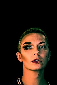 Portrait of a transgender woman with half a makeup on the face