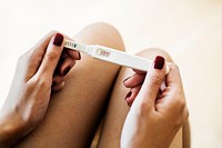 Woman holding a positive pregnancy test