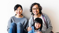 Smiling Japanese family with a daughter sitting on the floor