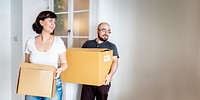 Happy couple moving in together and carrying boxes blank space banner