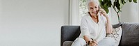 Cheerful elderly woman talking on a phone on a couch