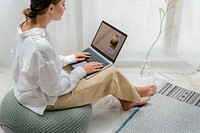 Woman using a laptop on a bean bag