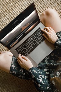 Woman on a wicker mat using a laptop