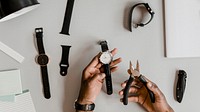 Horologist fixing a watch with pliers