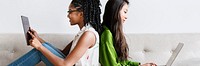 Diverse women sitting together using digital devices