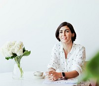 Happy woman wearing a smartwatch sitting at her desk