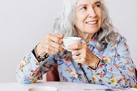 Cheerful grandmother sipping coffee in a cafe