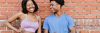 Sporty couple standing by a brick wall