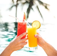 Couple toasting with cocktails by the pool