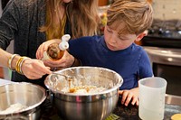 Mom teaching son how to bake in the kitchen