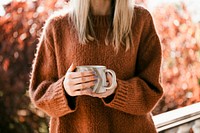 Woman drinking a cup of warm herbal orange tea