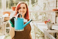 Female gardener with a blue watering can