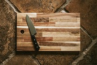 Chef&#39;s knife on a wooden cutting board flatlay